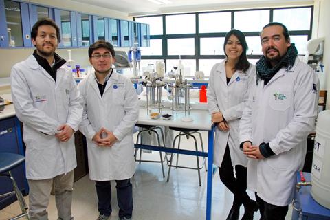 Cuatro personas en un laboratorio, vestidas con batas blancas, posando para la foto.