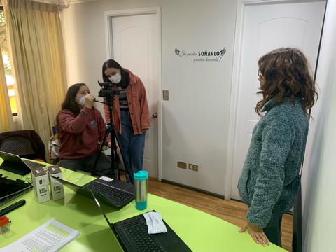 Un grupo de personas está trabajando en un ambiente de oficina con cámaras y computadoras.