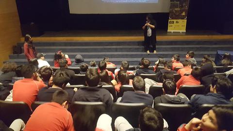 Un encuentro en un auditorio con un grupo de estudiantes atentos a una presentación.
