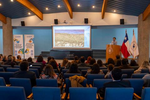 Un expositor presenta en un seminario en la Universidad Católica del Maule ante un público atento.