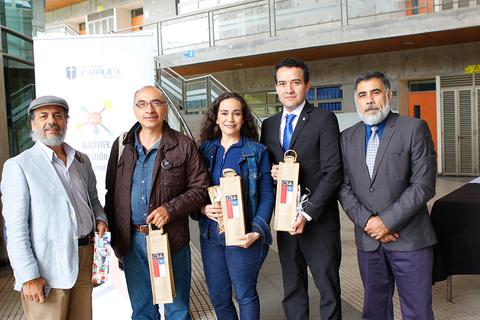 Grupo de personas posando en un evento con bolsas en mano en un ambiente académico.