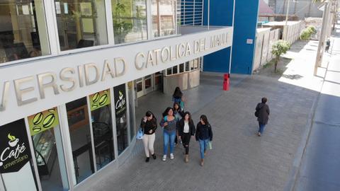Grupo de estudiantes caminando frente a la Universidad Católica del Maule.