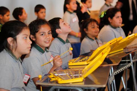 Niños en una clase de música, tocando instrumentos coloridos.