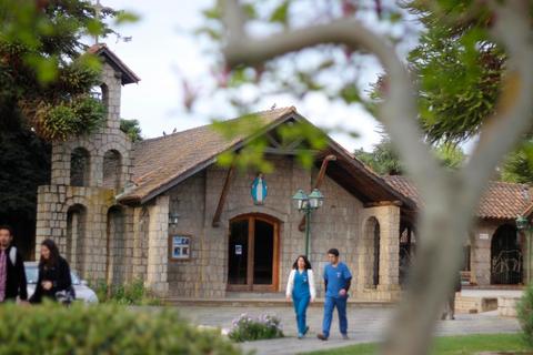 Una casa de estilo rústico con un jardín y personas caminando en su exterior.