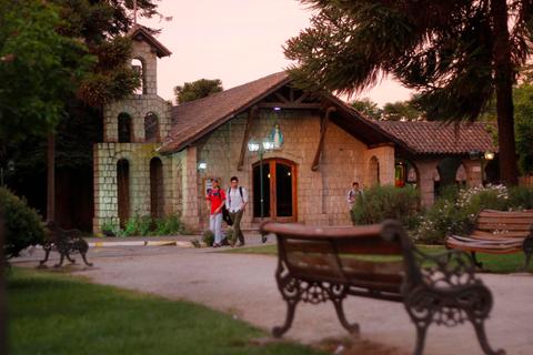 Una casa de campo con un ambiente sereno y personas caminando por el parque.
