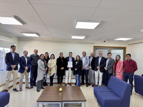 Un grupo de personas posando en una sala moderna con muebles confortables.