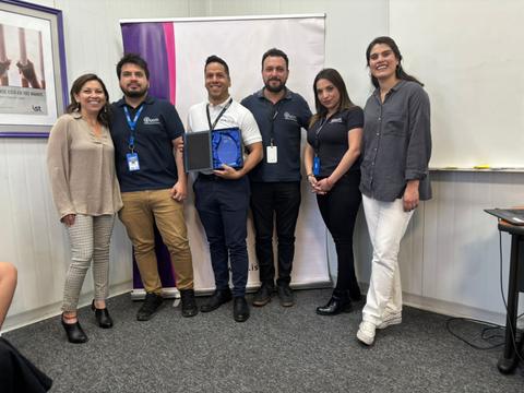 Un grupo de seis personas posando para una foto en un evento académico.