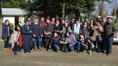 Un grupo de personas sonrientes posando juntas al aire libre en un parque.