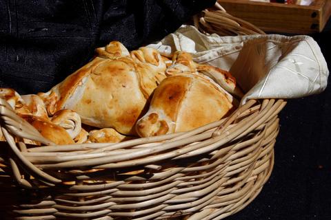 Una cesta de mimbre con empanadas doradas y crujientes.