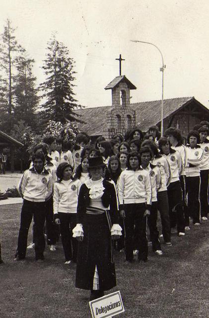 Un grupo de personas posando en un evento al aire libre frente a una iglesia.