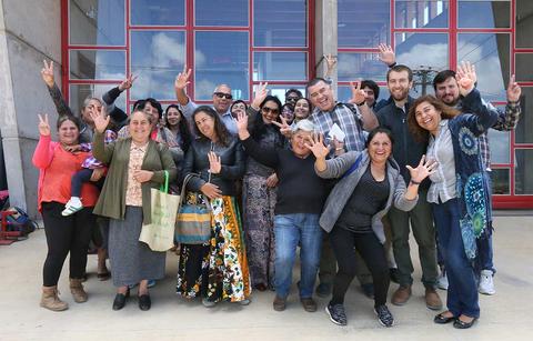 Un grupo de personas sonrientes posando juntas en una foto frente a un edificio.