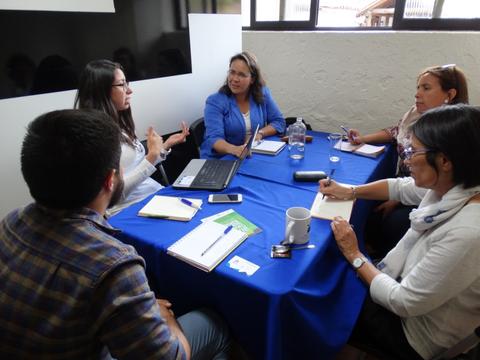 Un grupo de personas discutiendo en una mesa durante una reunión.