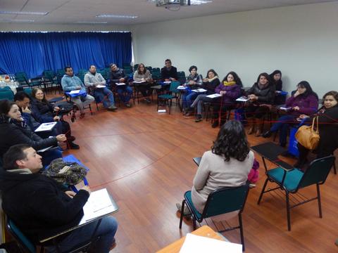 Un grupo de personas participa en una reunión en un salón de clases.