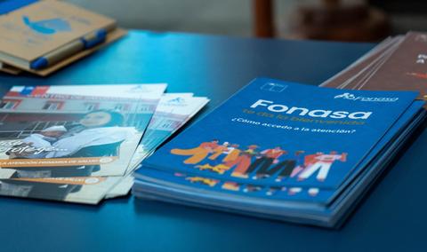 Una mesa con folletos informativos sobre Fonasa y otros temas relacionados con la salud.