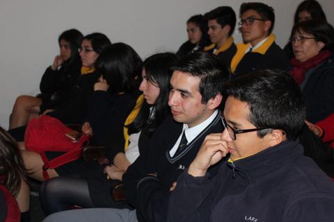 Un grupo de jóvenes sentados prestando atención en un evento.