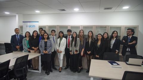 Grupo de personas posando en una sala de trabajo moderna con decoración institucional.
