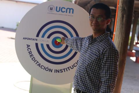 Una persona interaccionando con un panel informativo de una universidad.