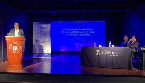 Un conferenciante expone sobre políticas públicas de movilidad en un evento académico.