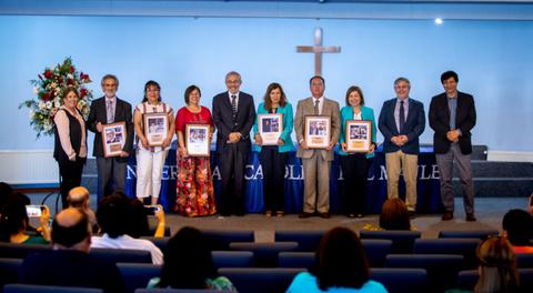 Un grupo de personas sosteniendo marcos con fotografías en un evento en una iglesia.