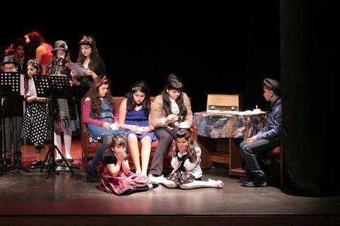Un grupo de niños y adolescentes en un escenario durante una representación teatral.