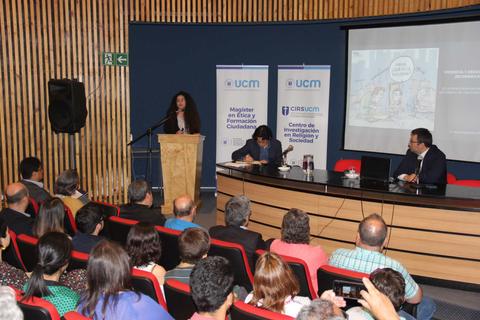 Un evento académico en el que una ponente presenta ante un auditorio.