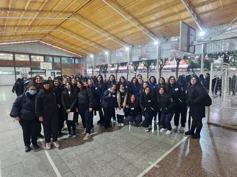 Un grupo de estudiantes sonrientes posando en un gimnasio escolar.