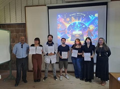 Un grupo de seis personas posando con certificados frente a una presentación creativa en una sala.