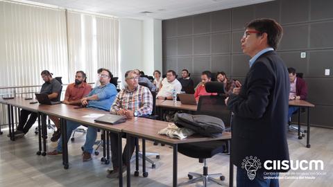 Un grupo de personas asiste a una presentación en un aula moderna.
