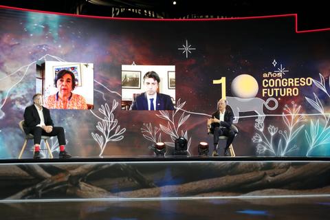 Una imagen del escenario de un congreso con participantes en videoconferencia.