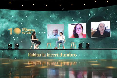 Un grupo de personas discute en un escenario durante un congreso virtual.