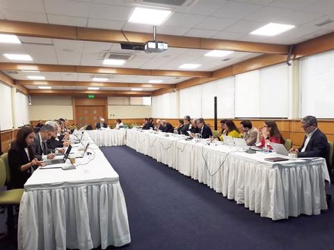 Reunión formal de un grupo de personas alrededor de una mesa en un ambiente cerrado.
