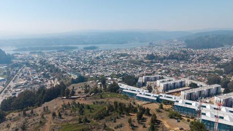 Una vista aérea de una ciudad costera chilena con edificios y un paisaje natural.