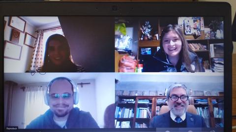 Una videollamada con cuatro participantes sonriendo frente a sus pantallas.