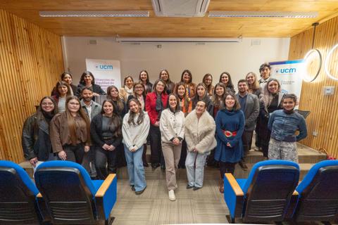 Un grupo diverso de mujeres sonrientes reunidas en una sala, mostrando unidad y camaradería.