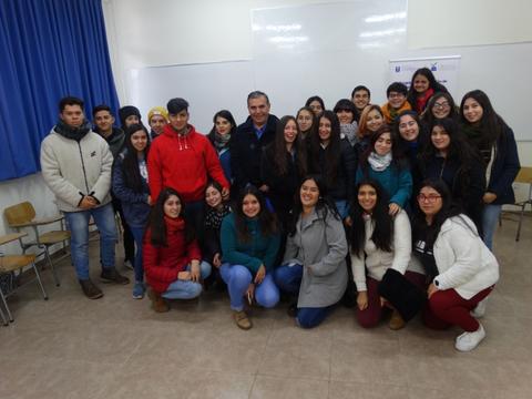 Grupo de personas posando sonrientes en un aula.