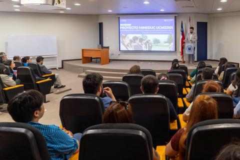 Una presentación sobre el proyecto del MINEDUC en un auditorio lleno de estudiantes.