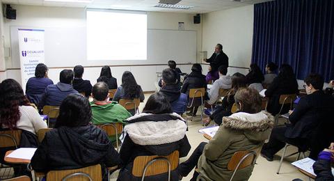 Un grupo de personas asiste a una presentación en un aula.