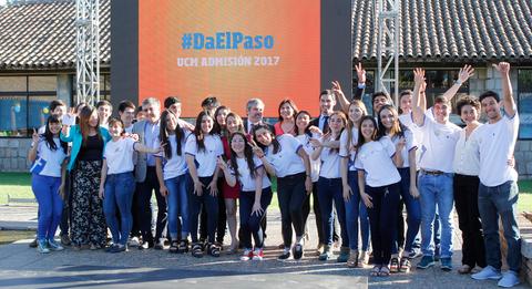 Un grupo de estudiantes sonrientes celebra un evento al aire libre frente a una gran pantalla con el lema '#DaElPaso'.