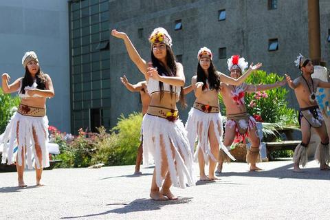 Un grupo de jóvenes realizan una danza tradicional con vestimenta típica en un ambiente natural.