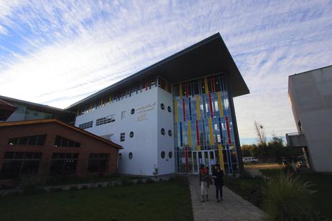 Una edificación moderna con colores vibrantes y un cielo despejado de fondo.