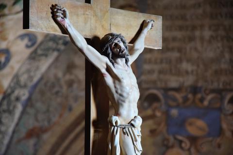 Escultura de Cristo crucificado en una cruz de madera.