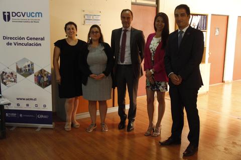Un grupo de cinco personas posando en un ambiente interior frente a un banner institucional.