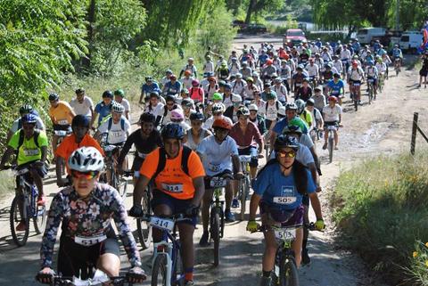 Un gran grupo de ciclistas participa en una carrera al aire libre.