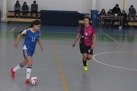 Una jugadora de fútbol sala está a punto de hacer un pase mientras otra jugadora la marca.