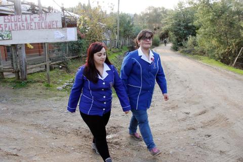 Dos mujeres caminan por un camino rural vistiendo chaquetas azules.