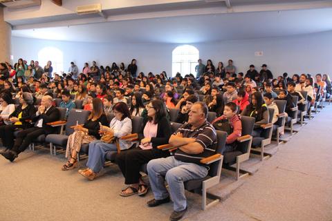 Una multitud de personas sentadas en un auditorio durante un evento.