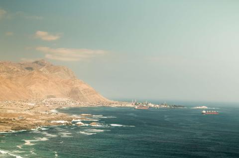 Una vista panorámica de la costa chilena con montañas y barcos en el mar.