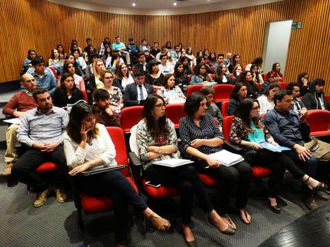 Un grupo numeroso de personas sentadas en un auditorio durante una presentación.