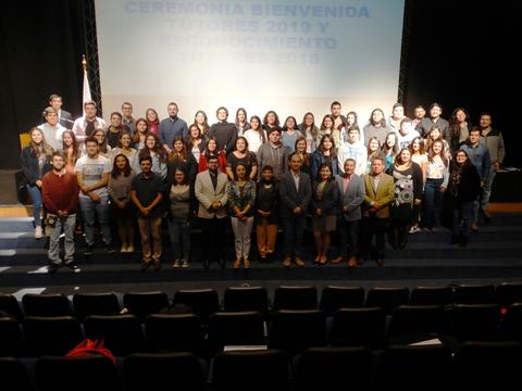 Un grupo de personas posa juntas en una ceremonia de bienvenida y reconocimiento.