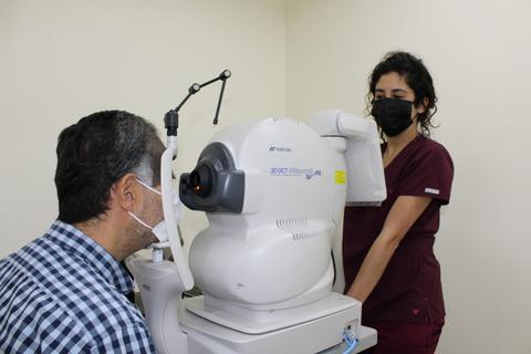 Un paciente se somete a un examen ocular mientras una profesional de la salud lo atiende.